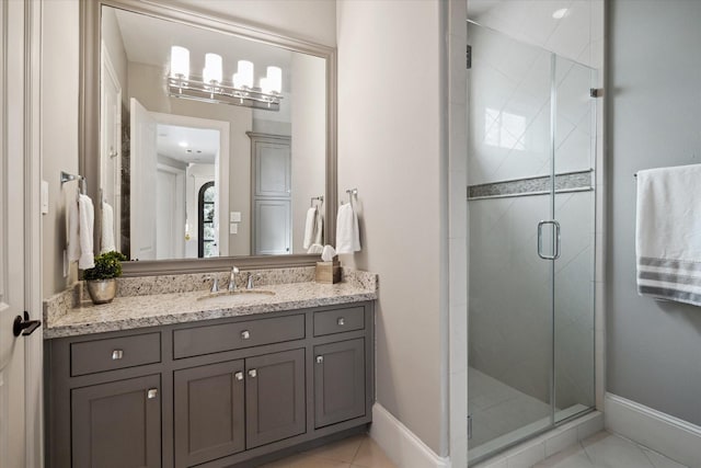 bathroom with tile patterned flooring, walk in shower, and vanity