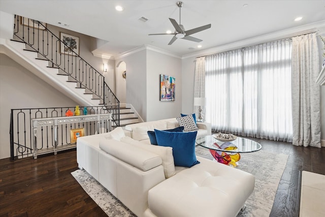 living room with dark hardwood / wood-style flooring, ceiling fan, and crown molding