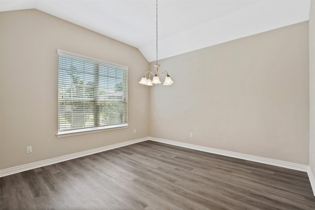 spare room with dark hardwood / wood-style flooring, vaulted ceiling, and an inviting chandelier