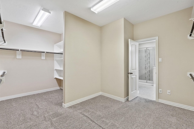 walk in closet featuring light colored carpet