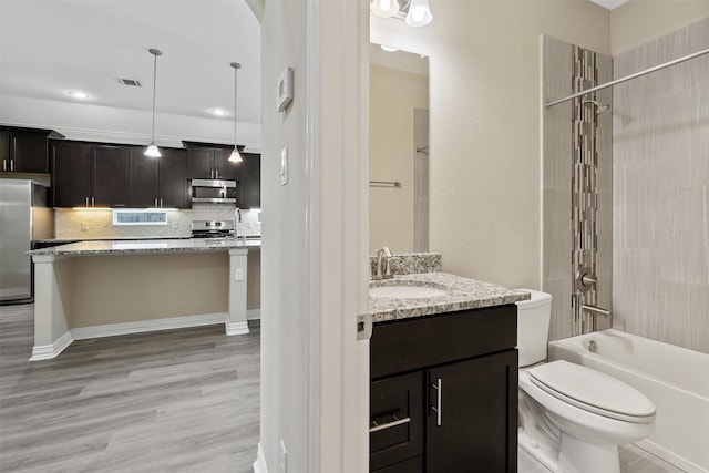 full bathroom with decorative backsplash, tub / shower combination, vanity, hardwood / wood-style flooring, and toilet