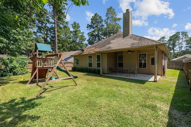 back of house with a lawn, ceiling fan, a patio area, and a playground