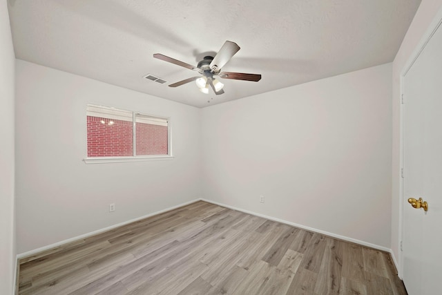 empty room featuring ceiling fan and light hardwood / wood-style flooring