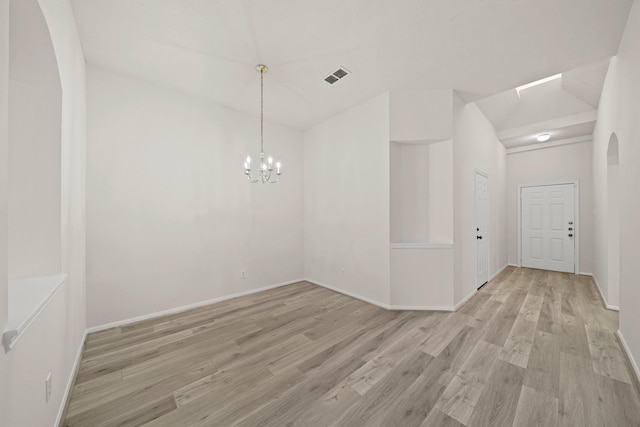 unfurnished room featuring an inviting chandelier and light wood-type flooring