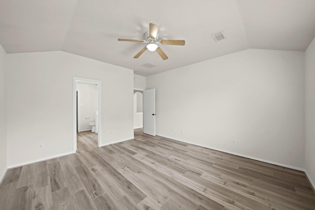 unfurnished bedroom with lofted ceiling, light wood-type flooring, ceiling fan, and connected bathroom