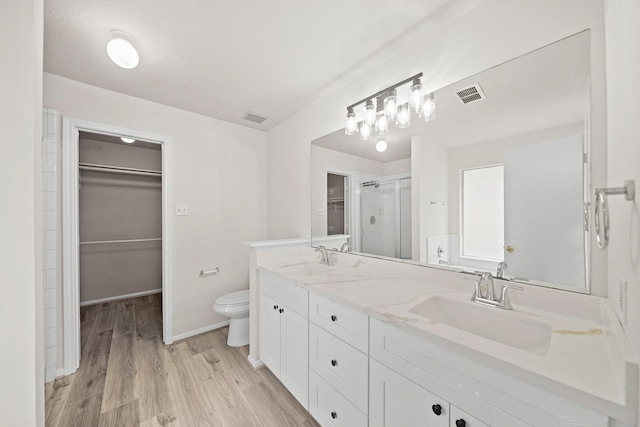 bathroom featuring toilet, a shower with door, wood-type flooring, and vanity