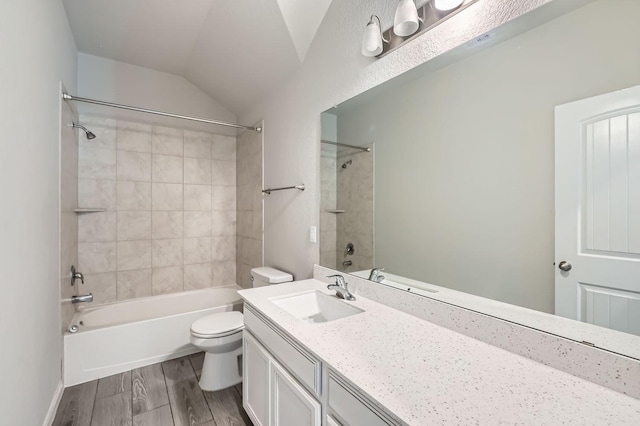 full bathroom featuring tiled shower / bath combo, toilet, vanity, and vaulted ceiling