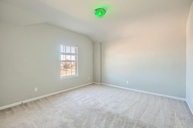 carpeted empty room with lofted ceiling