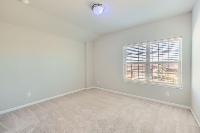 carpeted spare room featuring lofted ceiling