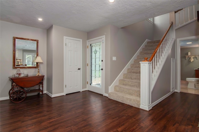 foyer with a textured ceiling and dark hardwood / wood-style floors