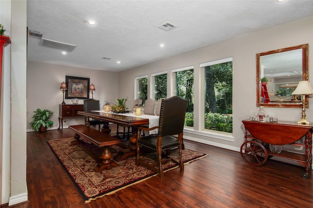 dining space with dark wood-type flooring and a textured ceiling