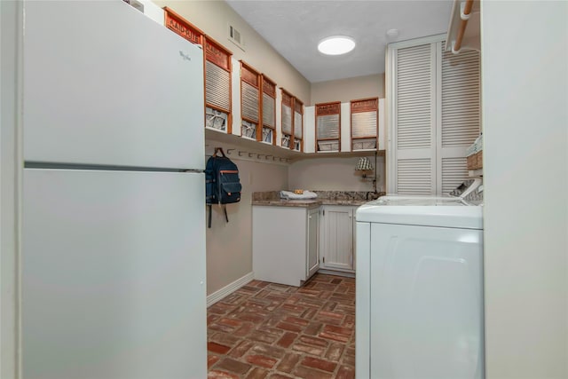 laundry area with washing machine and dryer and cabinets