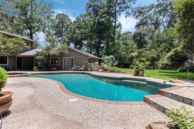 view of pool with a patio, a hot tub, and a lawn