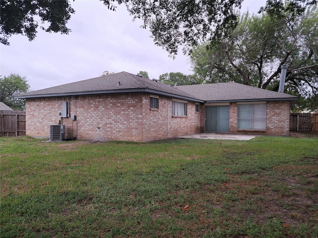 rear view of property featuring central AC unit, a patio area, and a yard