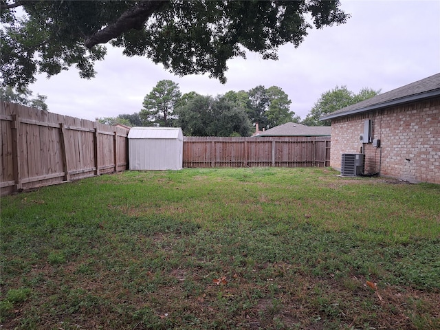 view of yard with central AC unit and a storage shed