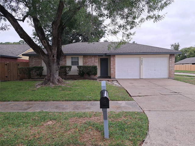 single story home with a garage and a front lawn