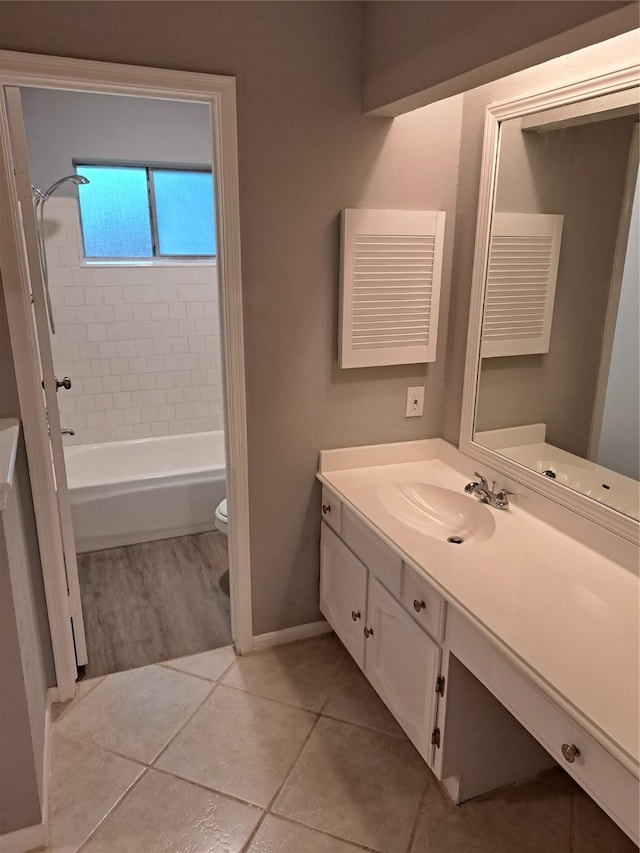 full bathroom featuring tile patterned floors, vanity, tiled shower / bath combo, and toilet