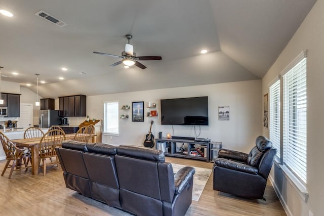 living room with ceiling fan, light hardwood / wood-style flooring, and lofted ceiling