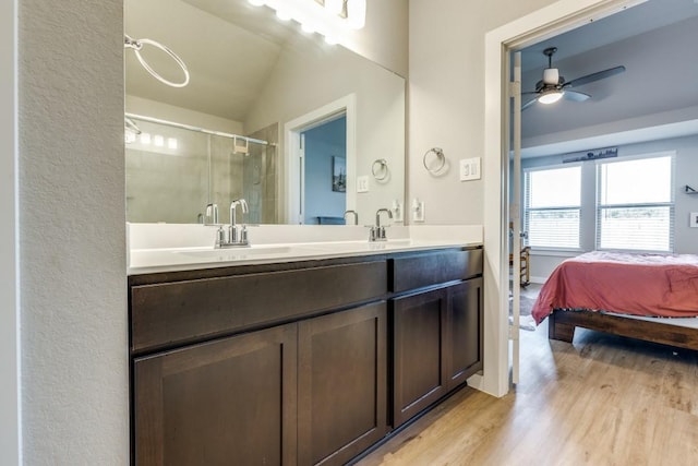 bathroom with vanity, lofted ceiling, a shower with door, hardwood / wood-style flooring, and ceiling fan