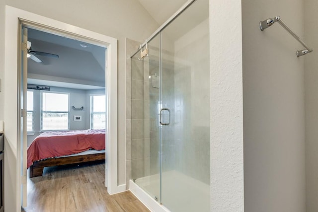 bathroom with lofted ceiling, ceiling fan, wood-type flooring, and an enclosed shower