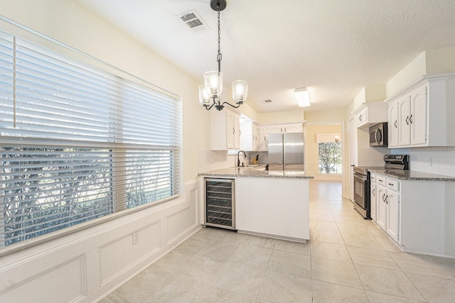 kitchen with stainless steel appliances, beverage cooler, sink, decorative light fixtures, and white cabinetry