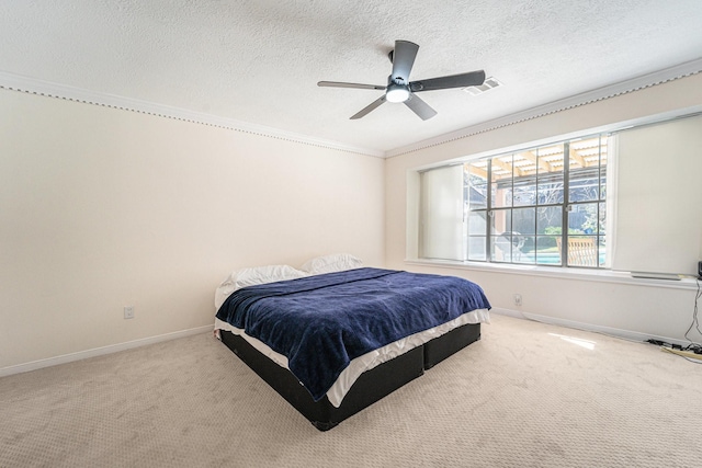 carpeted bedroom with ceiling fan, a textured ceiling, and ornamental molding