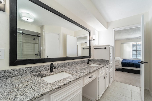 bathroom with a textured ceiling, vanity, ceiling fan, tile patterned flooring, and a shower with shower door