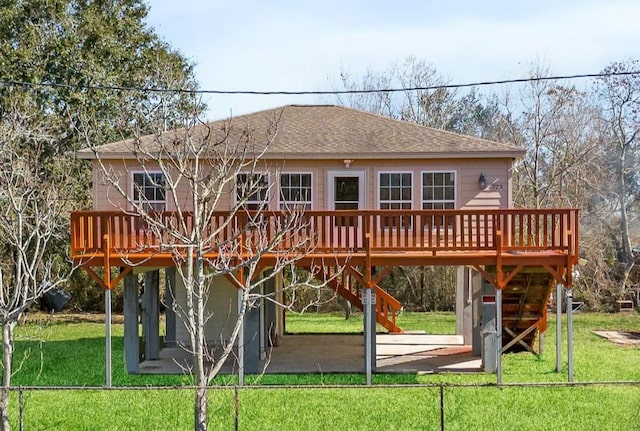 rear view of property featuring a patio, a yard, and a deck