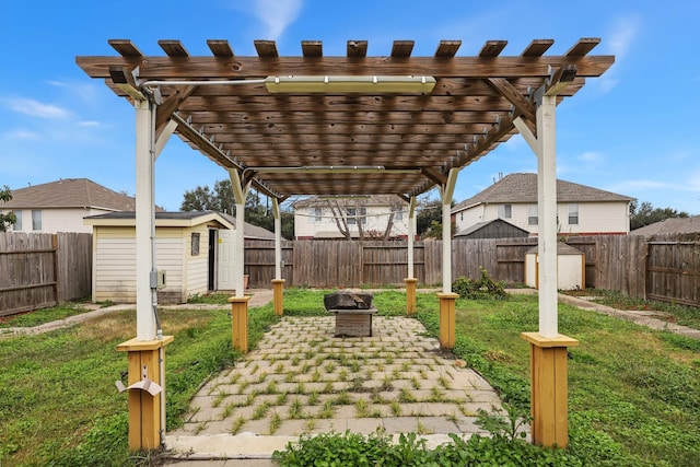 view of yard with a fire pit, a patio, a shed, and a pergola