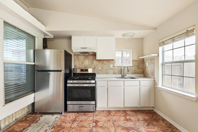 kitchen with stainless steel appliances, decorative backsplash, lofted ceiling, white cabinetry, and sink