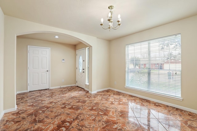 unfurnished room featuring a chandelier