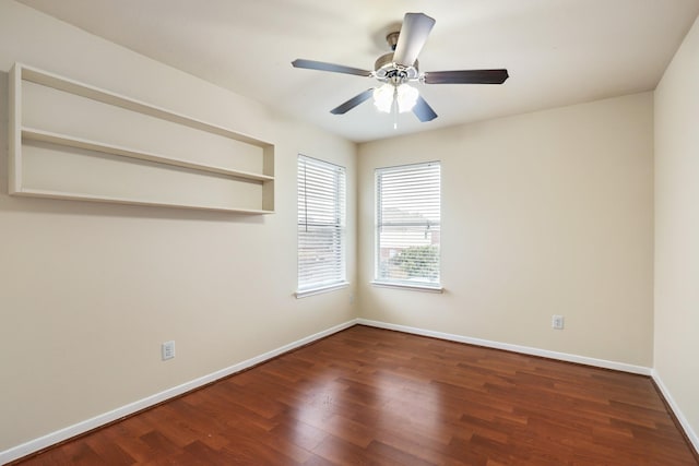 empty room with ceiling fan and dark hardwood / wood-style flooring