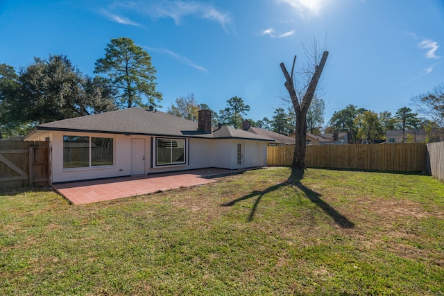 rear view of house with a patio and a lawn