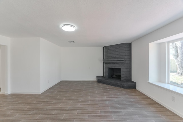 unfurnished living room featuring a fireplace and a textured ceiling