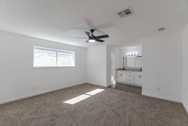 unfurnished living room with ceiling fan and dark colored carpet