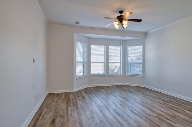 empty room with light wood-type flooring, ceiling fan, and crown molding