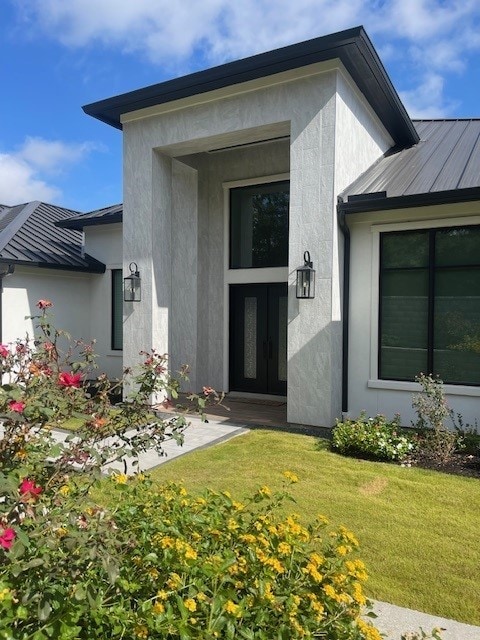 view of exterior entry with a yard