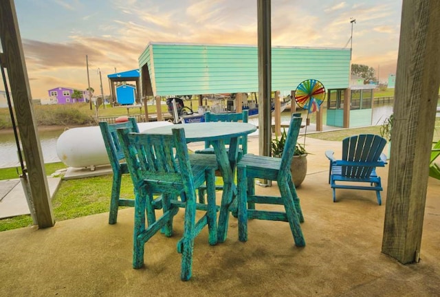 patio terrace at dusk featuring a water view