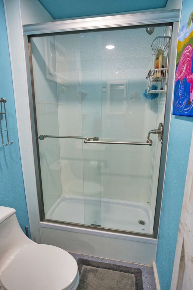 bathroom featuring tile patterned floors, toilet, and bath / shower combo with glass door