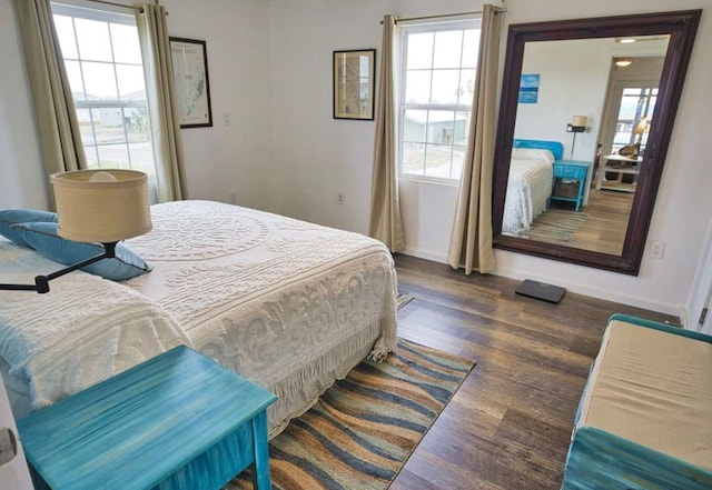 bedroom featuring multiple windows and dark wood-type flooring