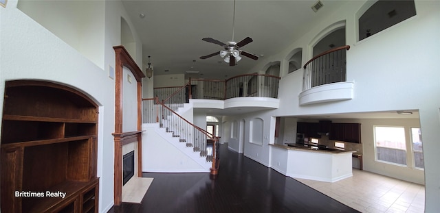 interior space with a towering ceiling and ceiling fan