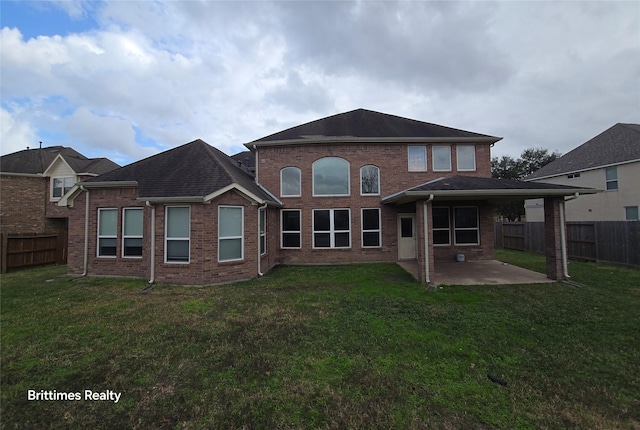 back of house featuring a lawn and a patio