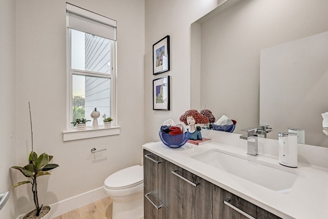 bathroom with vanity, toilet, and wood-type flooring