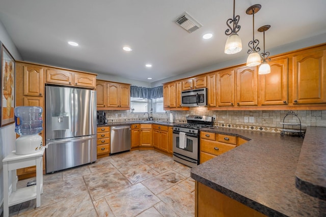 kitchen with stainless steel appliances, pendant lighting, decorative backsplash, and sink