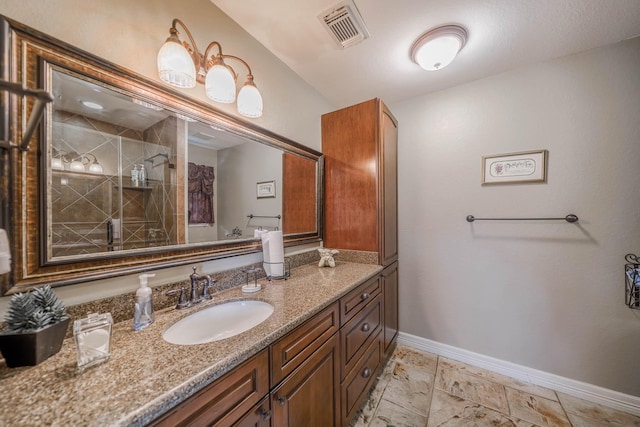 bathroom with a shower with shower door and vanity