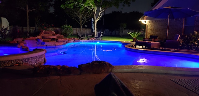 view of pool at twilight