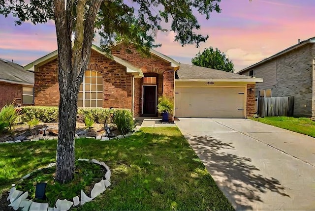 ranch-style home featuring a lawn and a garage