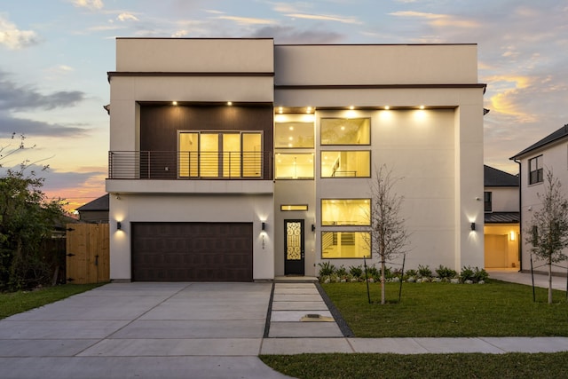 contemporary house featuring a yard, a balcony, and a garage