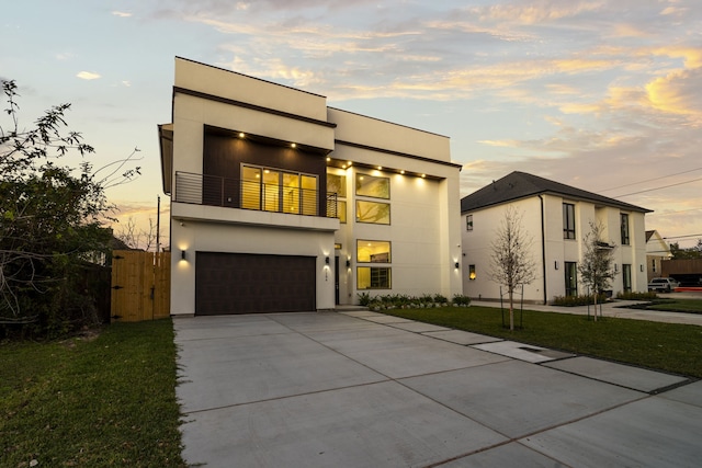 modern home featuring a lawn, a balcony, and a garage