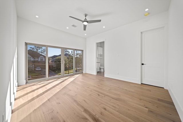 unfurnished bedroom featuring ensuite bath, ceiling fan, and light wood-type flooring